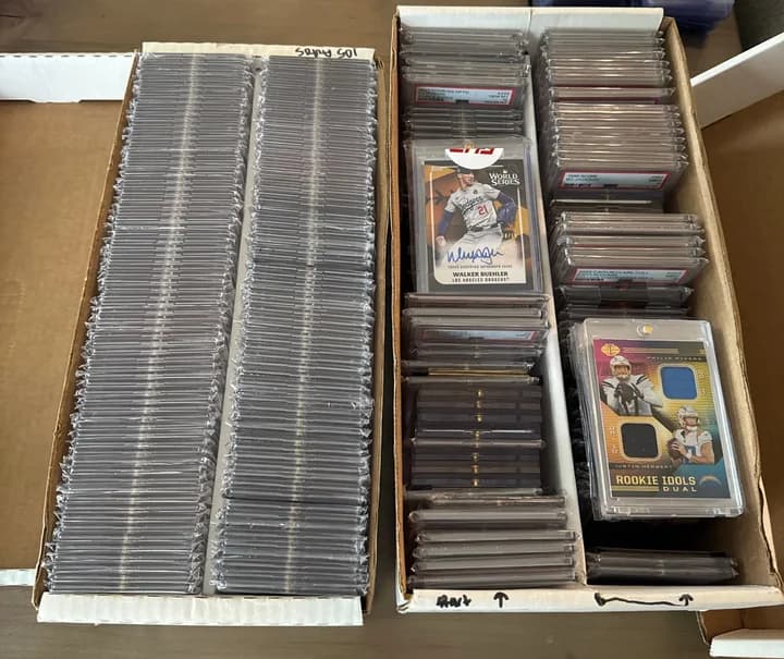 Two boxes filled with graded card slabs, including a Walker Buehler autograph and a Philip Rivers and Justin Herbert dual relic card