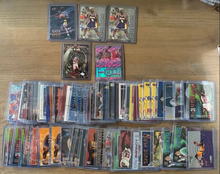 Rows of protected Michael Jordan and Kobe Bryant basketball cards laid out on a table