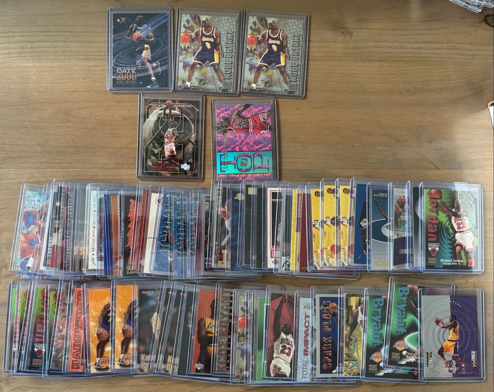 Rows of protected Michael Jordan and Kobe Bryant basketball cards laid out on a table
