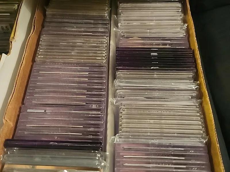 A cardboard box packed to the edges with hundreds of sports cards in protective holders, as it sat when we bought the collection