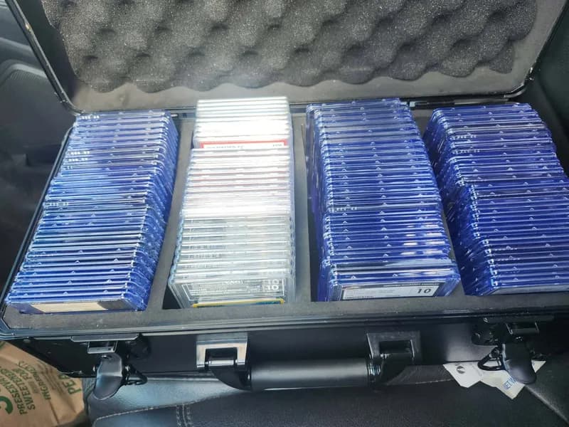 A hard travel case packed with rows of graded card slabs from PSA, CGC and more