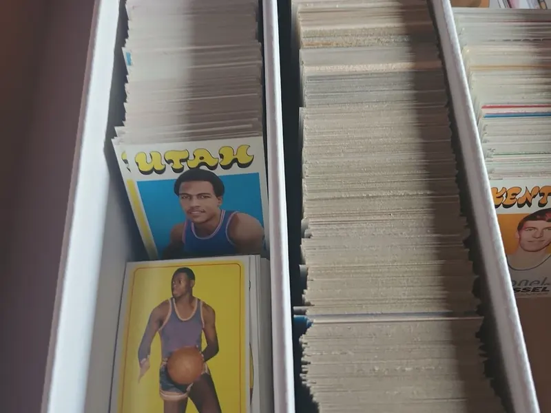 Rows of vintage basketball cards stored in a divided card box